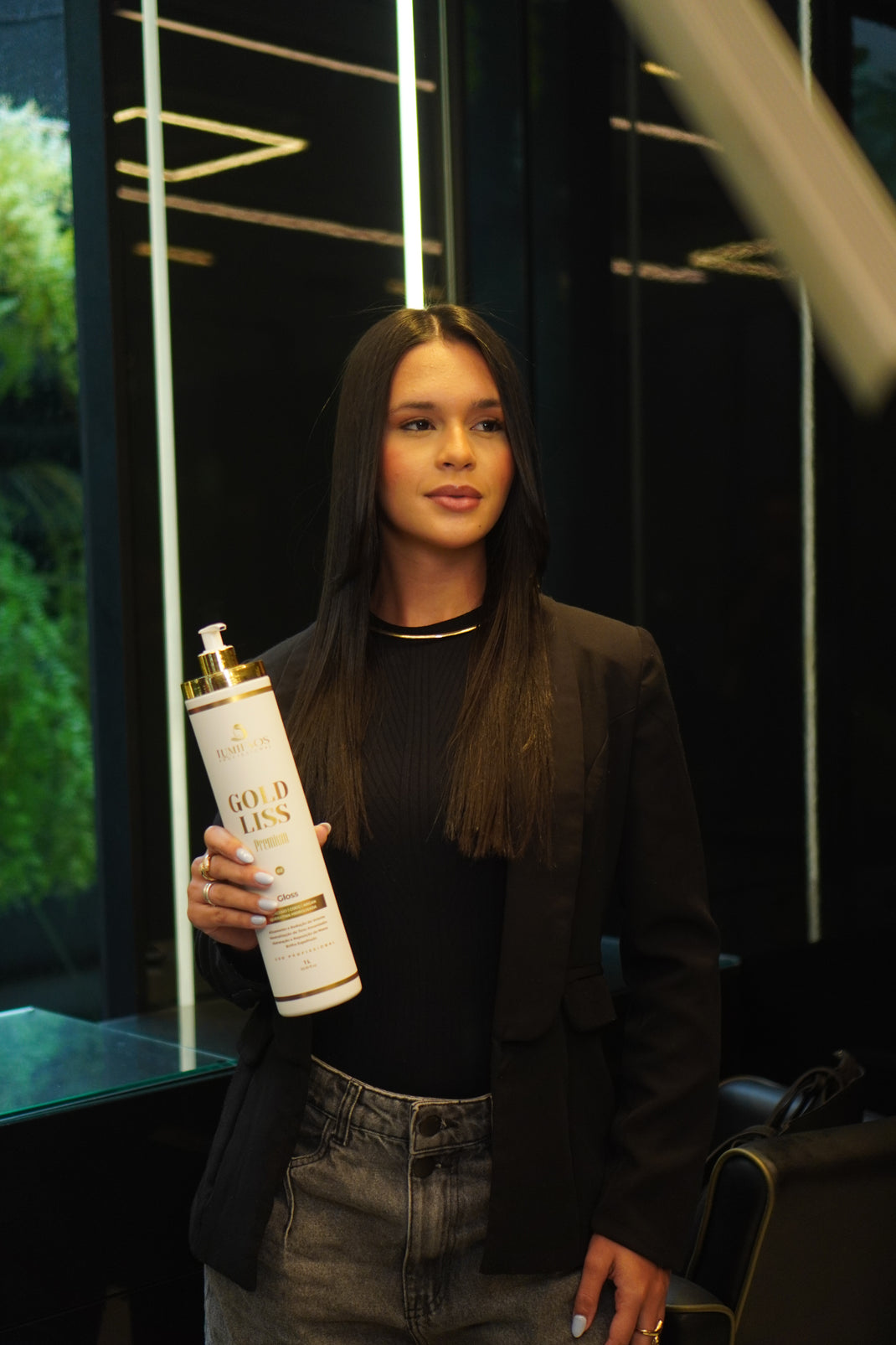 Modelo com cabelo alinhado segurando a Selagem Lumi Fios Gold Liss